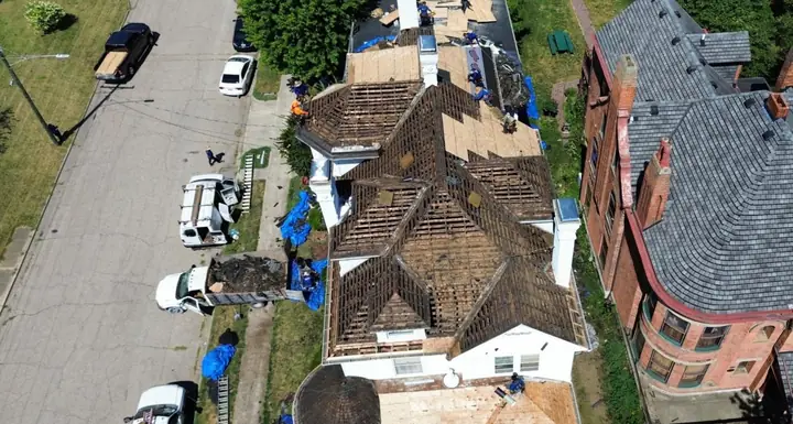 Before: historic home roof torn down to the skip sheathing, seen from a drone