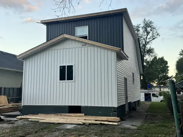 Rear elevation in white board and batten with a navy vertical siding accent