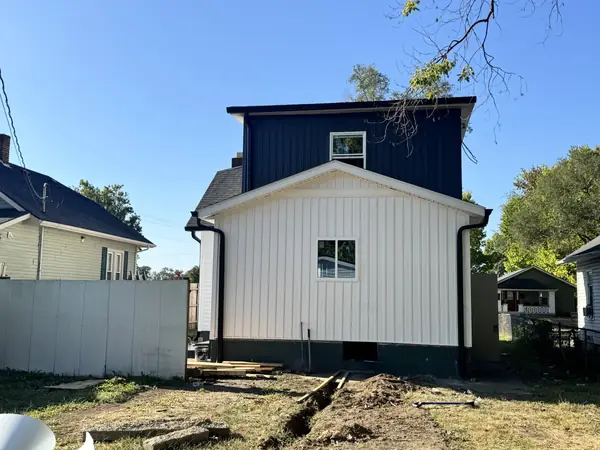 Board and batten siding with new black seamless gutters and downspouts