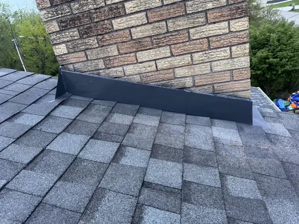 Chimney step and counter flashing sealed against new gray shingles
