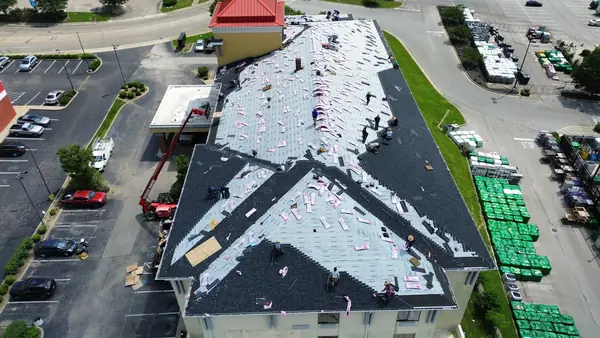 Aerial view of a commercial building mid-installation with bundles staged