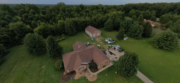 Aerial view of a finished roof on a country home and detached garage