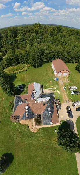 Drone view of a country estate roof replacement surrounded by woods