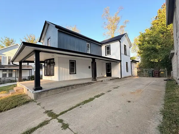 Modern farmhouse with a new covered front porch, black posts and board and batten siding