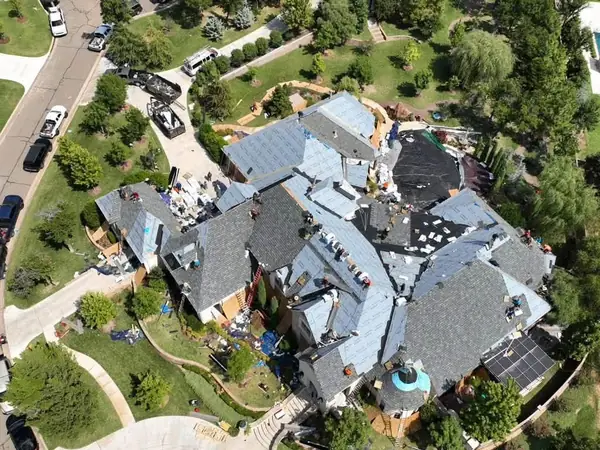 Drone view of a large custom home roof replacement with multiple hips and valleys
