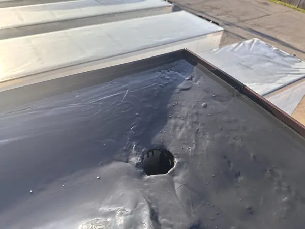 EPDM rubber roof membrane with a drain opening on a flat roof section