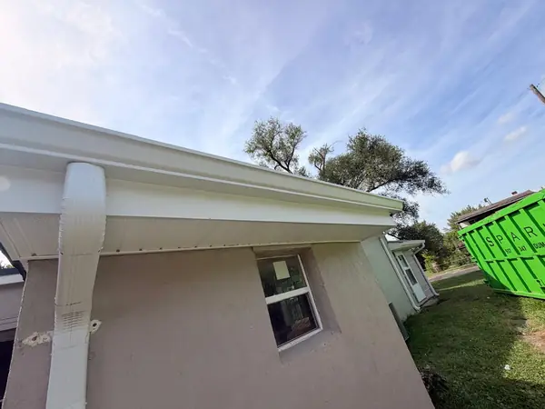 New white fascia, vented soffit and downspout on a stucco home