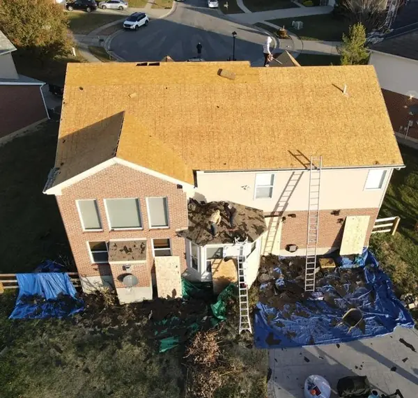 Drone view of a two-story brick home with all-new roof decking installed during a full replacement