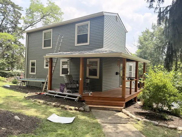 Two-story home in green siding with a new stained cedar porch