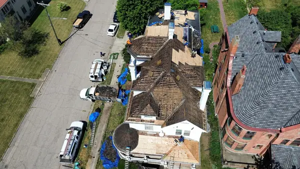 Crew tearing a historic home roof down to the original skip sheathing before new decking goes on