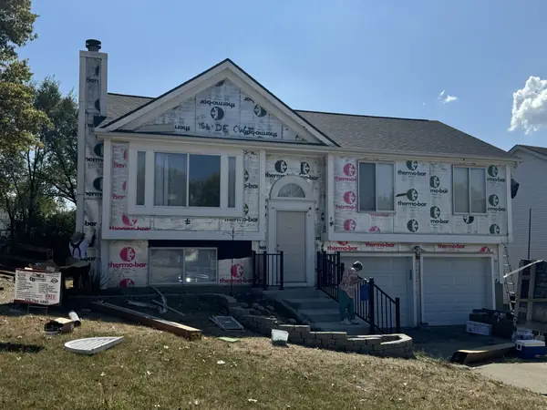 Split-level home wrapped in insulation board and house wrap ready for siding