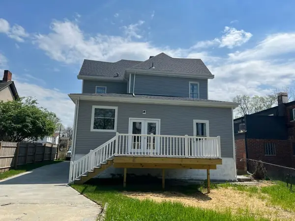New pressure-treated deck with white vinyl railing and stairs on a gray-sided home