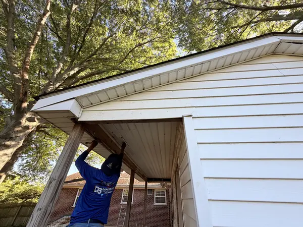 Technician repairing the soffit and beam of a covered side porch
