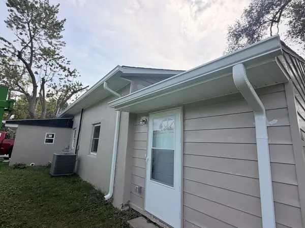 Rear addition finished in gray lap siding with white gutters and downspouts