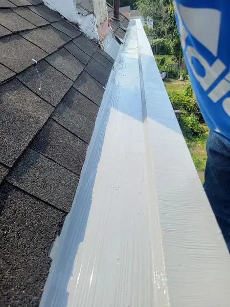 Built-in gutter sealed with a seamless white coating along the shingle edge