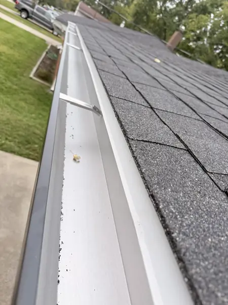 White seamless aluminum gutter with hidden hangers along a shingle roof